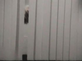 Парень с камерой в руках наблюдает за переодеванием девушки в окно