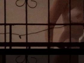 Девушка подглядывает за своим парнем в окно и снимает его на камеру