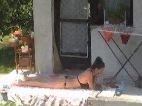 Сосед через окошко заснял одну девушку. которая лежала и загорала в купальнике во дворе