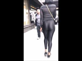Длинноногая тёлка в чёрных лосинах виляет на улице попой перед прохожими